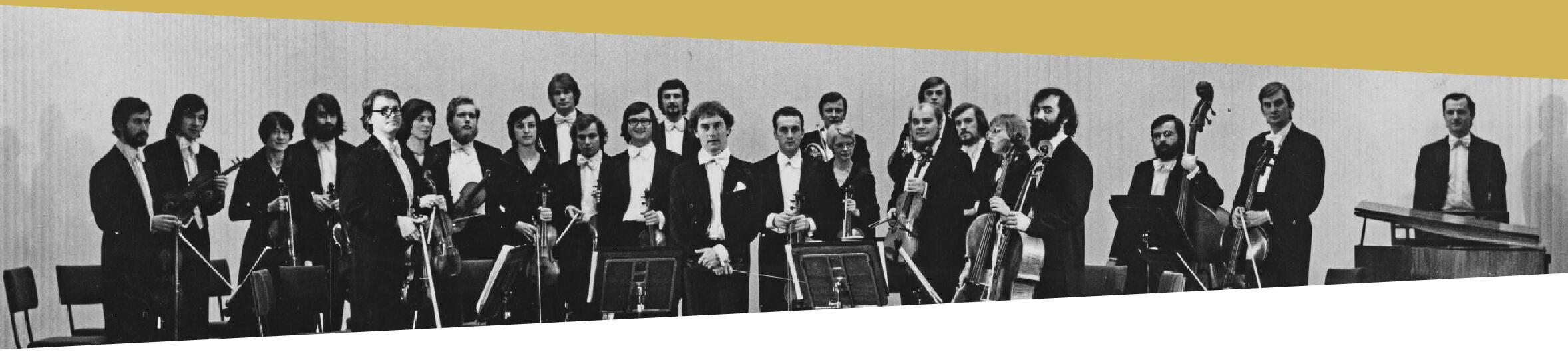 Czarno-biała zdjęcie grupowe: w sali koncertowej, na scenie, stoi grupa dwudziestu czterech osób – pięć kobiety i dziewiętnastu mężczyzn. Są to muzycy Polskiej Orkiestry Kameralnej. Wszyscy trzymają w dłoniach swoje instrumenty muzyczne. Na środku stoi Jerzy Maksymiuk – dyrygent orkiestry.